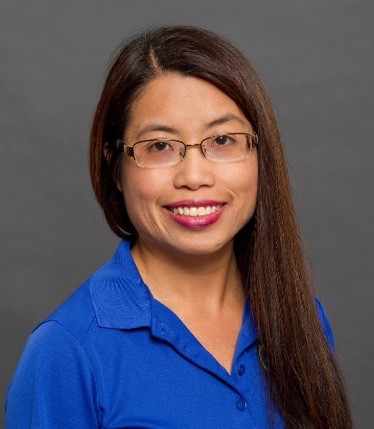 A picture containing person, smiling, blue, posing
Description automatically generated